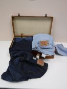 A vintage leather luggage case containing nine pairs of Levi jeans