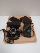 A tray containing four vintage cameras, including a Brownie, Agfa,