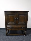 An Ercol double door cabinet fitted with a drawer,