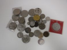 A tin of assorted British and foreign coins including crowns, half crowns, NZ shilling pieces,