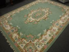 A Chinese fringed carpet on green ground,