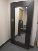 A large wood framed mirror in an oak finish