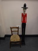 A child's rush seated chair and a carved wooden figure