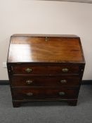 A George III mahogany bureau on bracket feet
