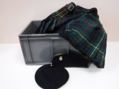 A crate containing militaria, including hats, kilts,