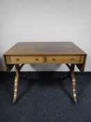 An inlaid mahogany Victorian style sofa table fitted two drawers