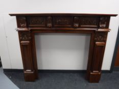 A heavily carved mahogany fire surround