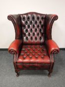 A red leather chesterfield armchair,