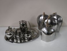 A five piece Old Hall stainless steel tea service together with ten cow bells