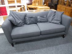 A Marks and Spencers two seater settee with scatter cushions (leg damaged)