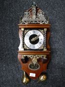 A continental wall clock with pendulum and weights