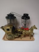 A tray containing brass horse and carriage models and two Tilley lamps