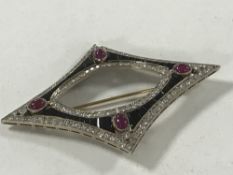 A diamond and jet brooch set with four cabochon rubies