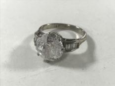 An 18ct white gold dress ring with diamond set shoulders,