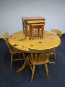 A circular pine pedestal dining table together with four chairs and a nest of tables