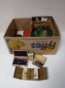 A box containing boxed playing cards, dominoes, game counters, model railway pieces,