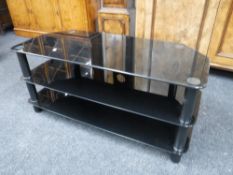 A black glass three tier LCD TV stand