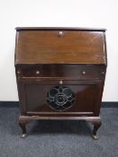An early 20th century mahogany bureau on Queen Anne style legs with a stained glass panel