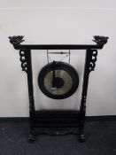 A Chinese gong and beater on a black lacquered stand
