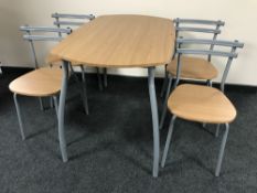 A contemporary pine effect kitchen table on metal legs together with four chairs