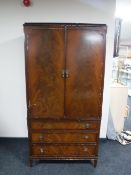 A mahogany double door hanging wardrobe fitted three drawers