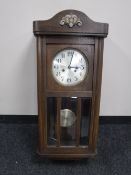 An early 20th century oak wall clock with silvered dial