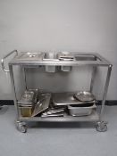 A stainless steel two tier Bain Marie trolley with a large quantity of Bain Marie pots and lids