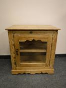 A pine single door glazed cabinet,