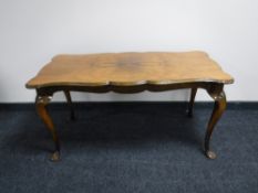 A figured walnut coffee table on Queen Anne style legs