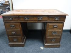 An early 20th century oak twin pedestal desk fitted nine drawers