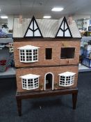 A dolls house on stand together with a dolls bungalow