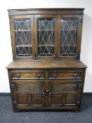 A carved oak kitchen dresser with leaded glass doors