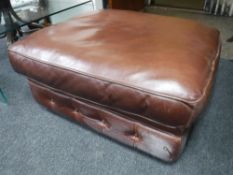 A brown button leather footstool