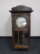 An early 20th century oak wall clock with silvered dial