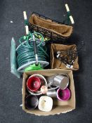 Several cast metal garden hanging baskets, hose pipe reel, planter, watering cans,