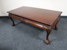 A mahogany coffee table on claw and ball feet