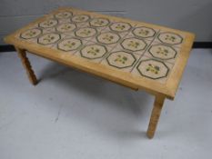 A blond oak tile top coffee table together with a contemporary glass topped coffee table