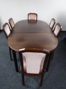 A late 20th century mahogany extending dining table with leaf together with a set of six chairs