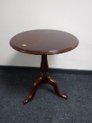 A reproduction mahogany pedestal occasional table