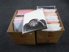 Two boxes containing new bedding and a box of new clothing sets