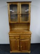 A pine double door dresser with glazed doors