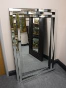 A contemporary all glass overmantel mirror