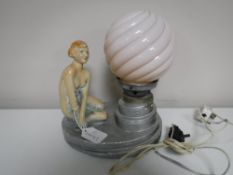 A chalk Art Deco table lamp with a pink glass shade