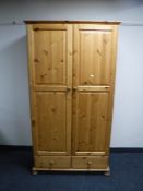 A pine double door wardrobe fitted two drawers