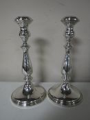 A pair of loaded silver candlesticks,