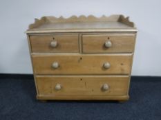 A Victorian stripped pine four drawer chest with gallery