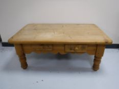 A stripped pine coffee table fitted two drawers