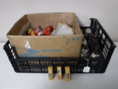A box containing a quantity of assorted spark plugs together with nine ceramic insulators