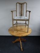 A circular pine pedestal kitchen table together with an armchair