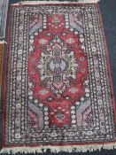 An Afghan rug of Caucasian design, on red ground,